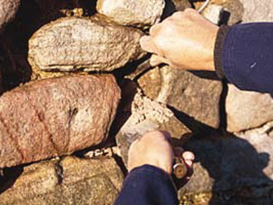 A person moving stones within a drystone wall